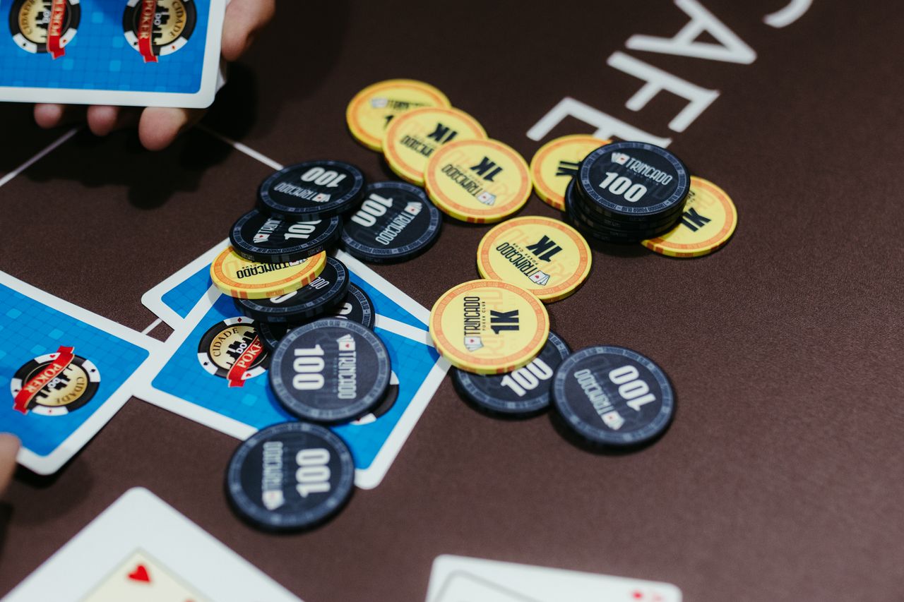 A close-up of poker chips and cards on a table during a game of Texas Hold'em.